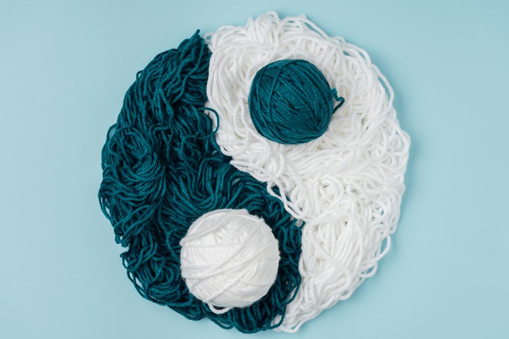 Widok z góry niebieski i biały przędzy, ułożone w yin yang znak na niebieskim tle - Zdjęcie, obraz