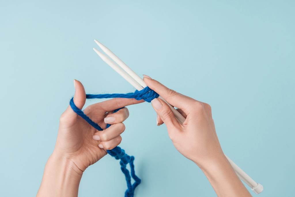 青い糸と青い背景に編み物白のニット針女の部分的なビュー - 写真・画像