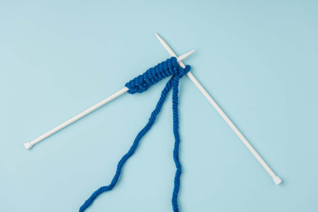 vista superior de fios azuis e agulhas de tricô branco no fundo azul
  - Foto, Imagem