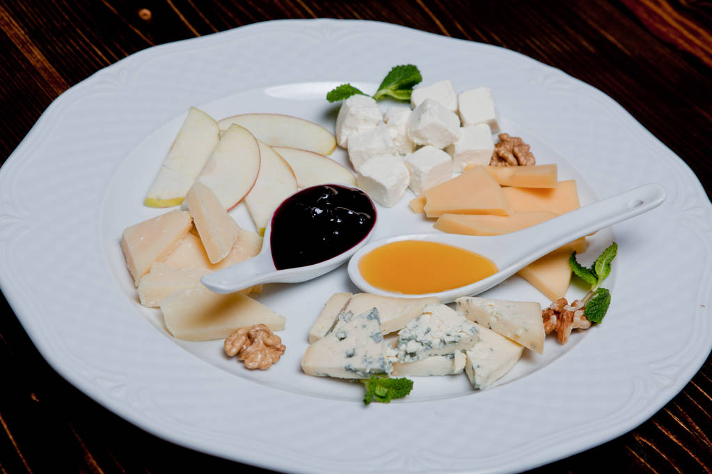 Cheese plate on a black table. Many kinds of cheese - a plate - Photo, Image