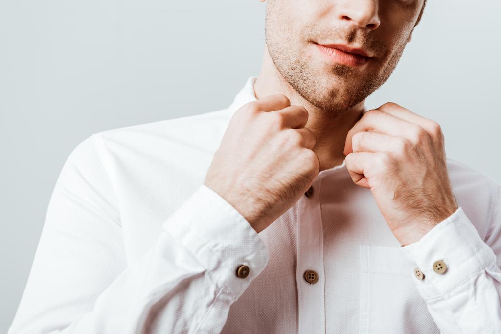 обрезанный образ красивого бизнесмена, застегивающего белую рубашку, изолированную на сером
 - Фото, изображение