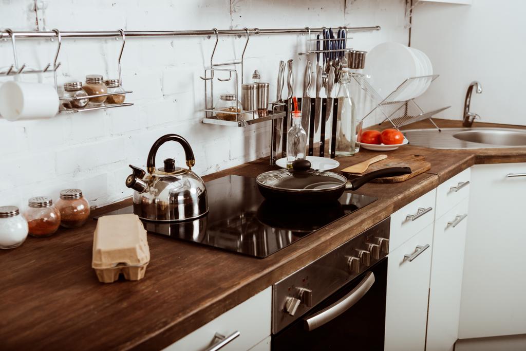 moderne keuken interieur met koekenpan en theepot op fornuis  - Foto, afbeelding