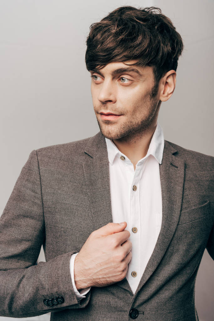 retrato de un joven hombre de negocios guapo mirando hacia otro lado en gris
 - Foto, Imagen