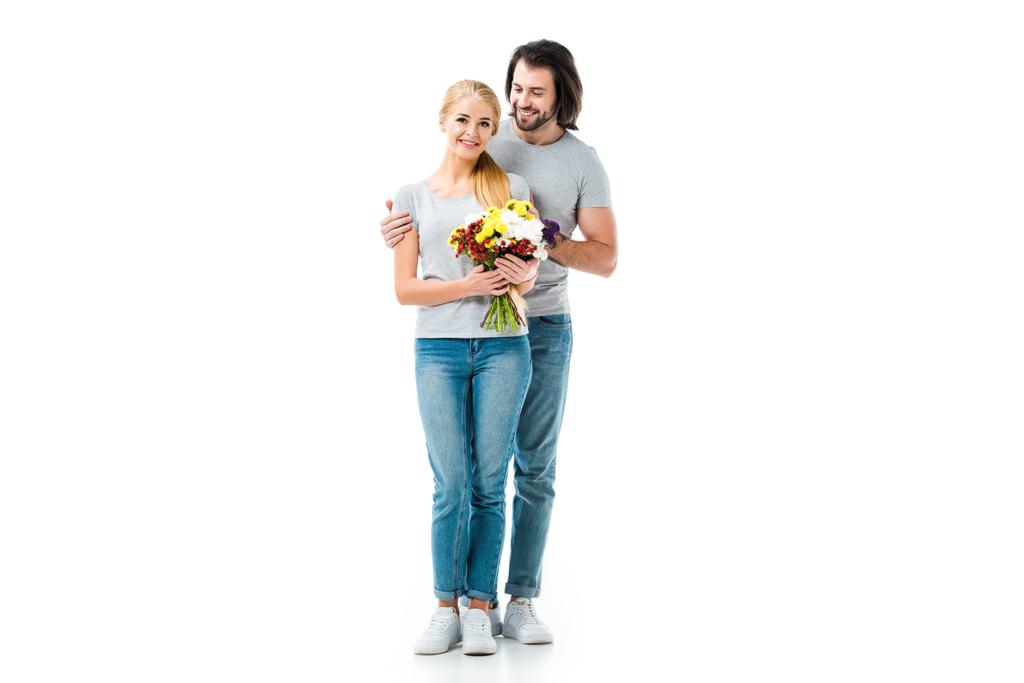glückliches Paar umarmt und Mädchen hält Blumen isoliert auf weiß - Foto, Bild
