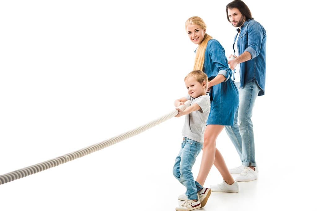 I genitori e il loro piccolo figlio in abiti di denim tirando corda isolata su bianco
 - Foto, immagini