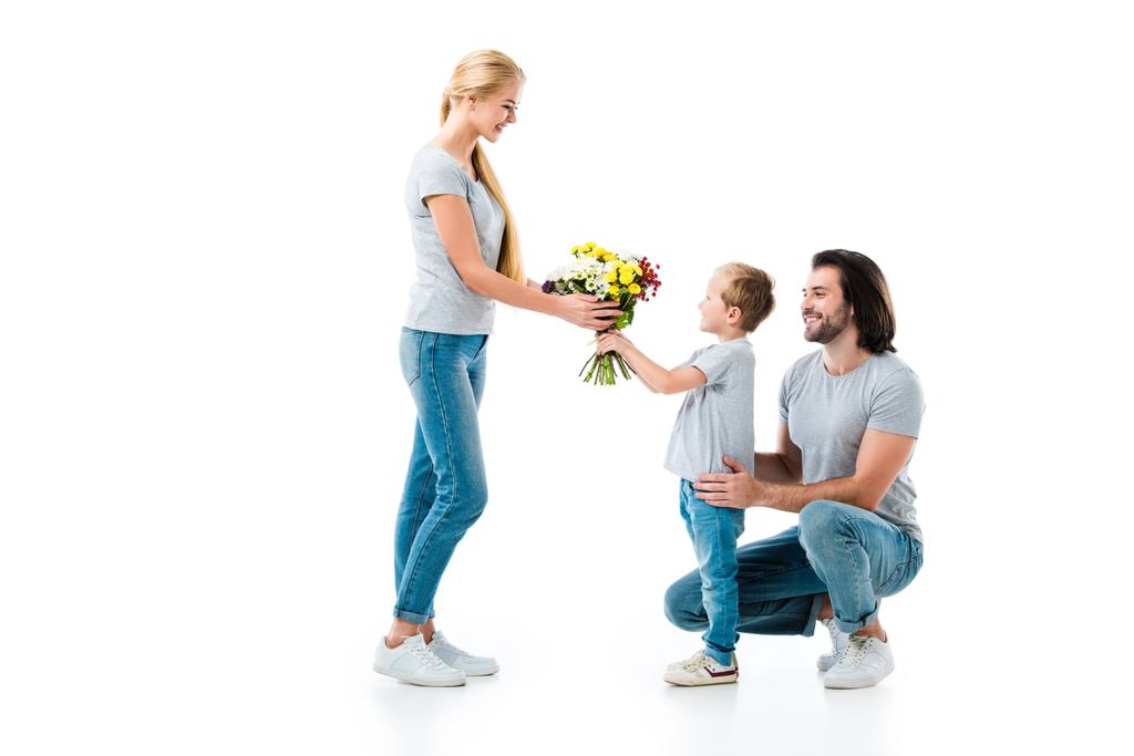 Son presenting bouquet of flowers his mother isolated on white - Photo, Image