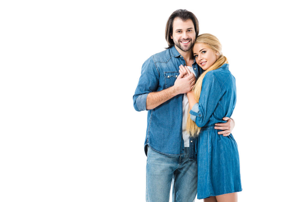 Preciosa pareja en jeans tomados de la mano y abrazos aislados en blanco
  - Foto, Imagen