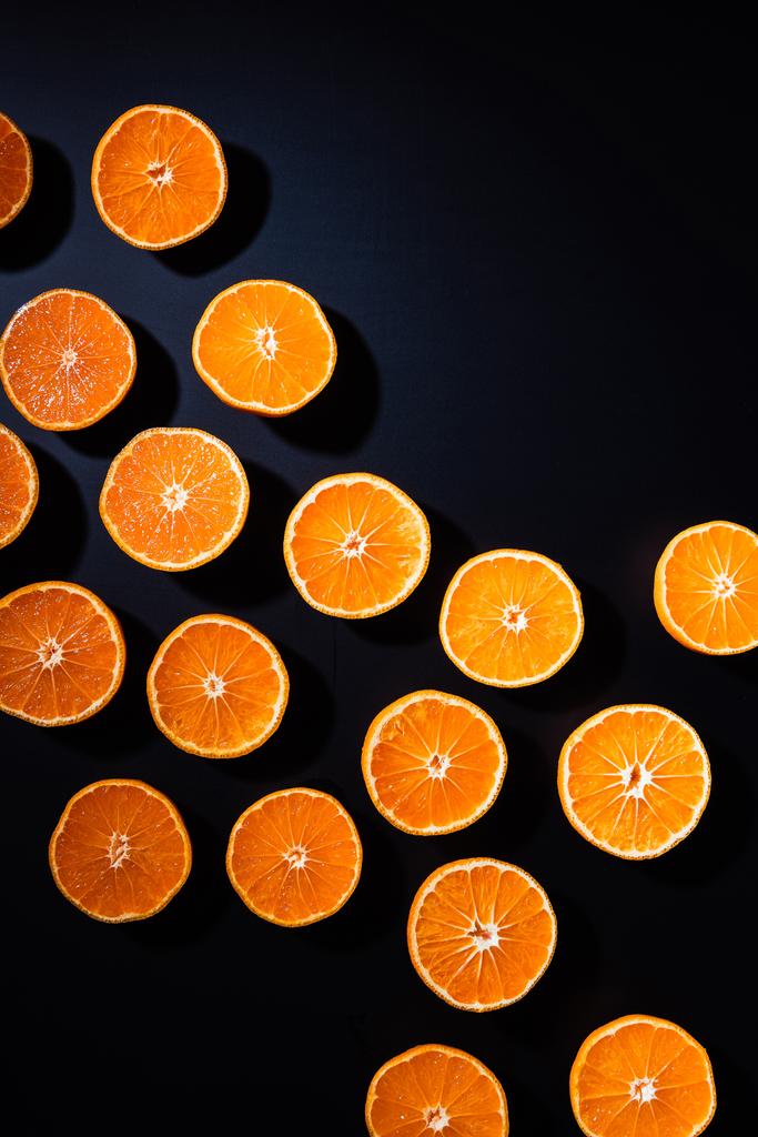 marco completo de corte arreglado mandarinas mitades sobre fondo negro
 - Foto, Imagen