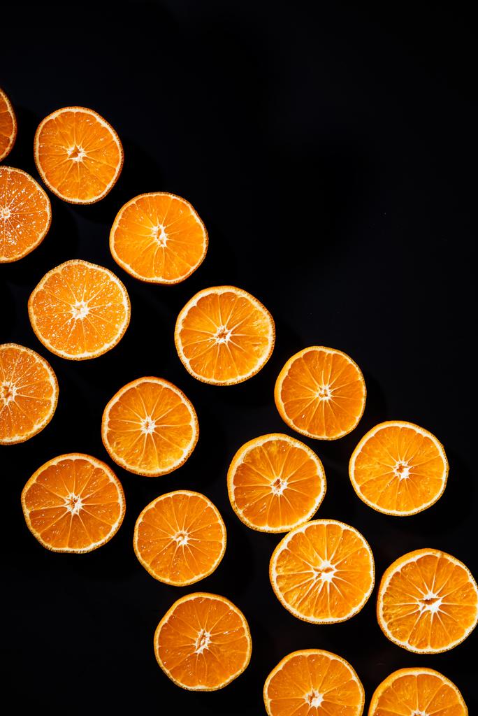 Vollbild aus arrangierten geschnittenen Mandarinenhälften auf schwarzem Hintergrund - Foto, Bild
