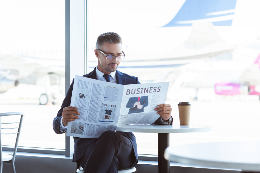 空港のカフェで新聞を読む大人のビジネスマン - 写真・画像
