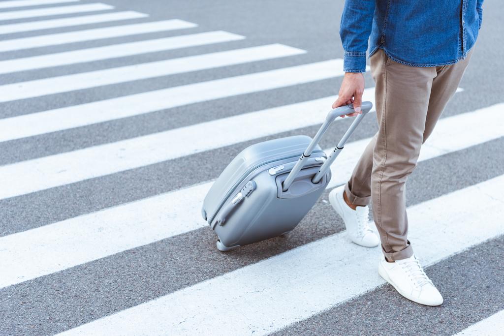 Vista cortada de um turista em sapatos brancos com saco de viagem cinza
 - Foto, Imagem