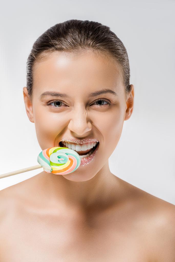 jeune femme avec du sucre sur les lèvres mordant sucette colorée
 - Photo, image