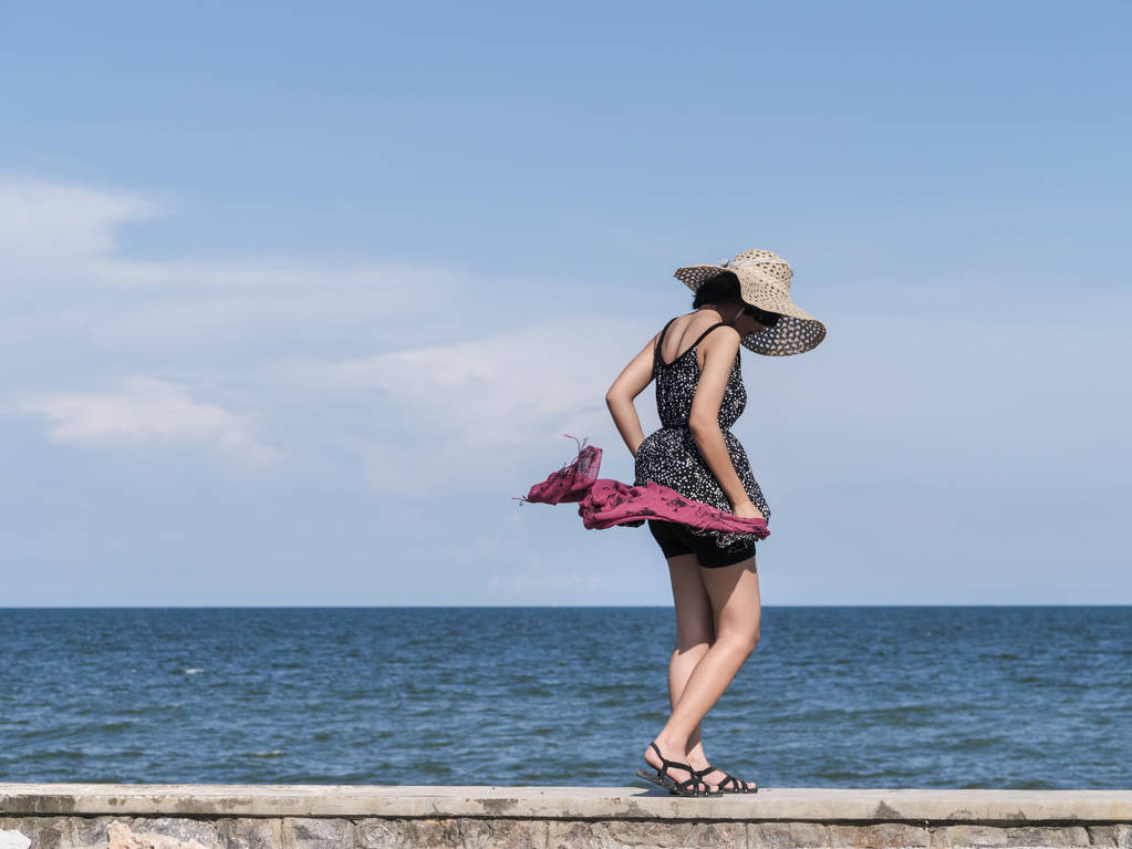 Boldog ázsiai tinédzser gazdaság sál a szél beach horizon hátterű, süt a nap. - Fotó, kép