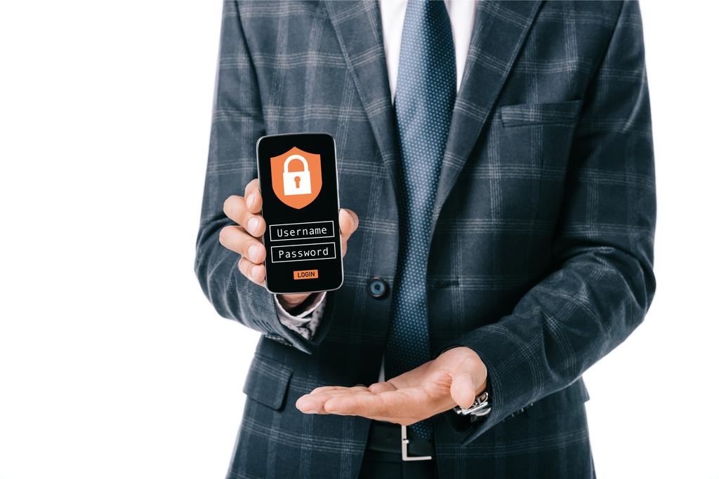 recortado disparo de hombre de negocios en traje que muestra el teléfono inteligente con el signo de seguridad cibernética en la pantalla aislada en blanco
 - Foto, Imagen