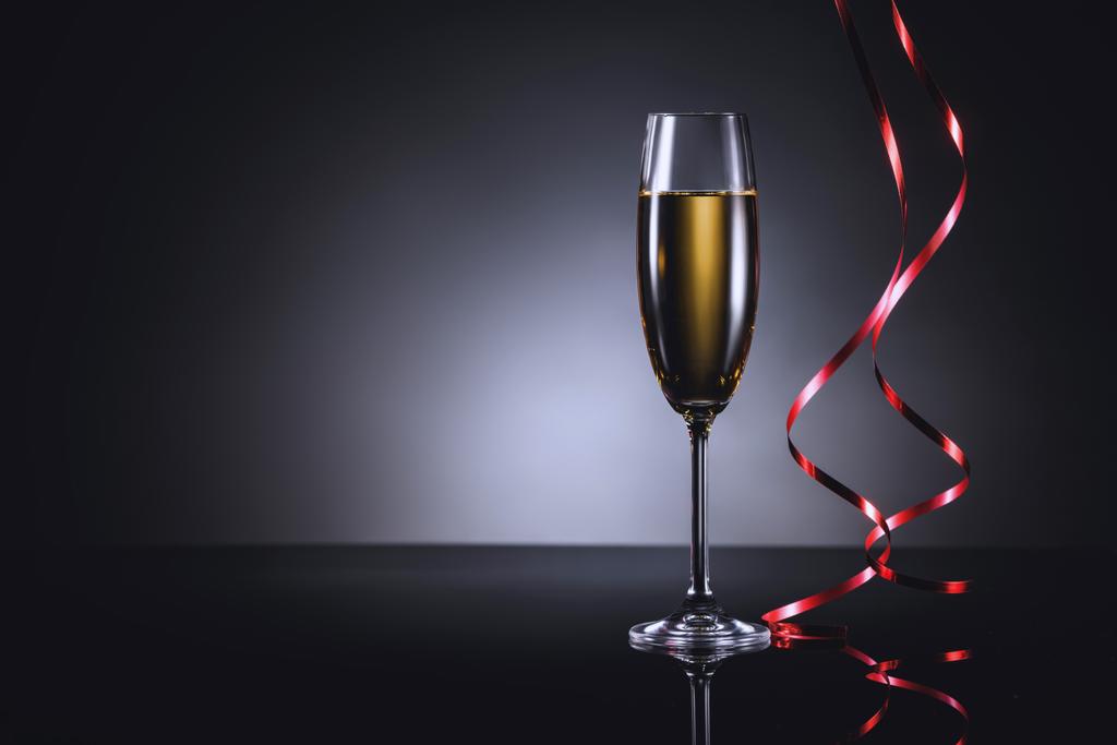 закрыть вид на бокал шампанского и праздничные конфетти на темном фоне
 - Фото, изображение
