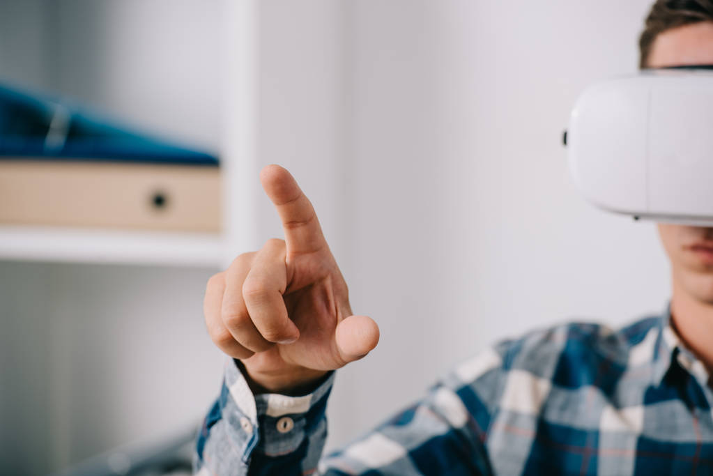 Mann in Virtual-Reality-Headset gestikuliert im Raum - Foto, Bild