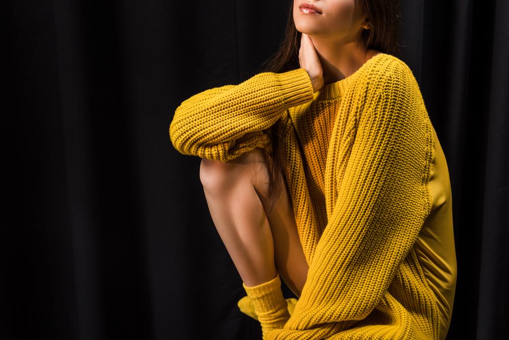 tiro recortado de mujer en suéter de lana amarillo sobre fondo negro
 - Foto, Imagen