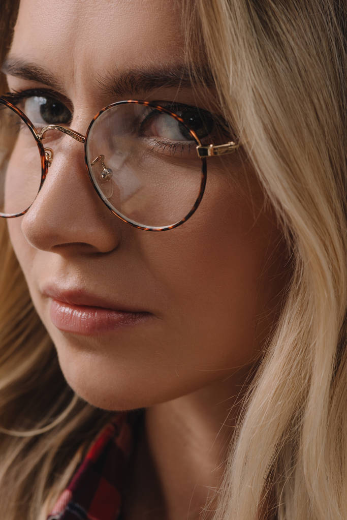 portrait of beautiful pensive woman in eyeglasses looking at camera - Photo, Image
