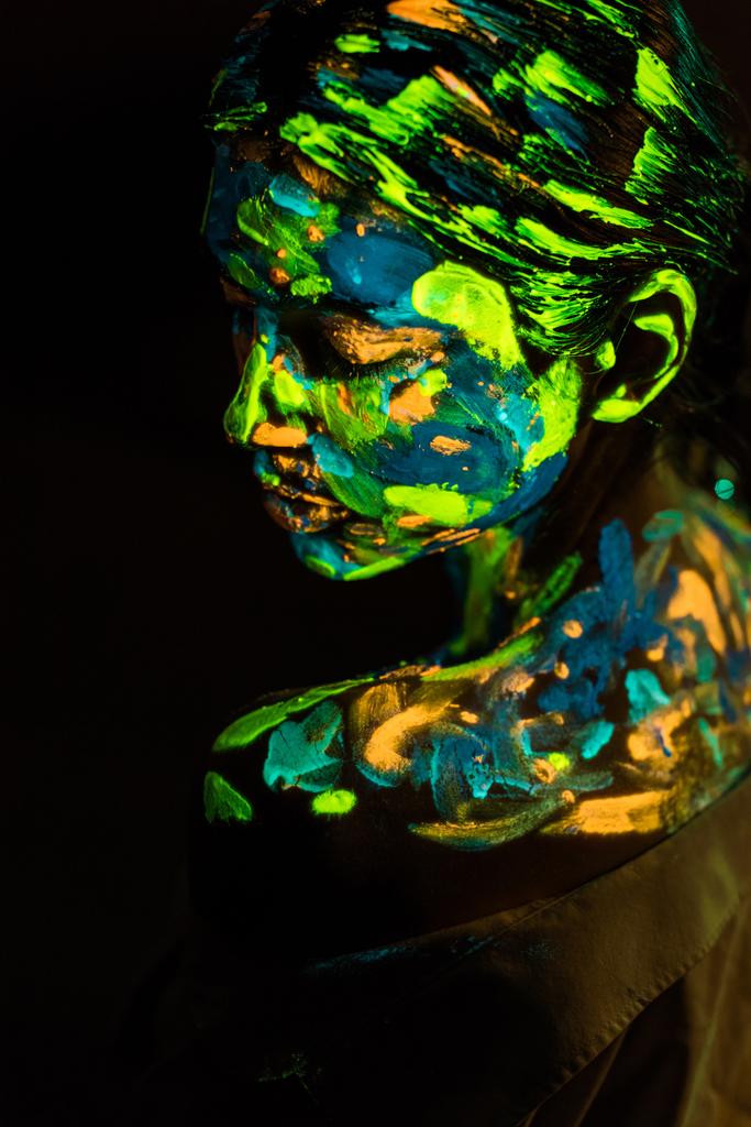 puolella näkymä nainen maalattu värikäs ultravioletti maalit mustalla taustalla
 - Valokuva, kuva