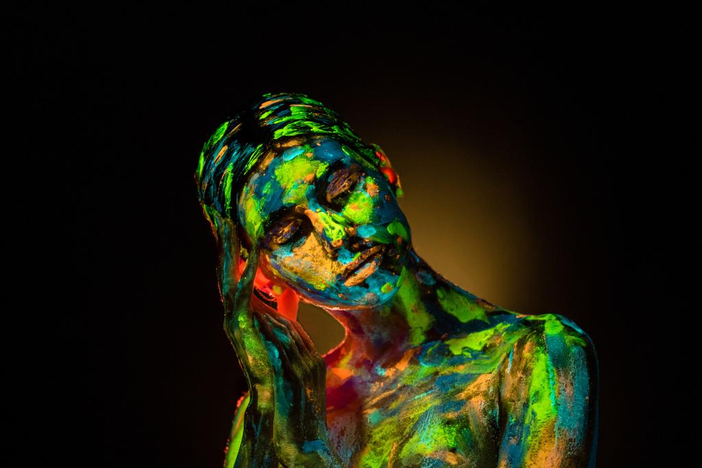 πορτρέτο του όμορφη γυναίκα με πολύχρωμα υπεριώδη χρώματα στο σώμα σε μαύρο φόντο - Φωτογραφία, εικόνα