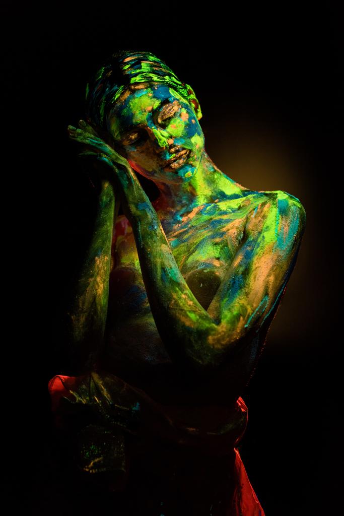 portrait of beautiful woman with colorful ultraviolet paints on body on black backdrop - Photo, Image