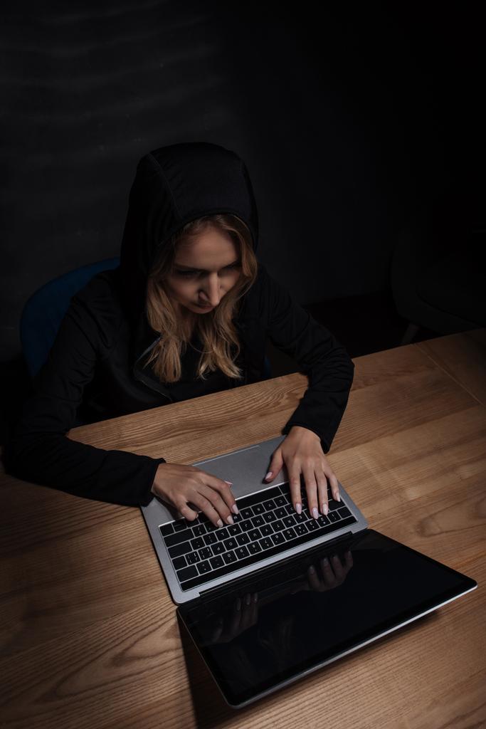 nő a fekete kapucnis pulcsi, laptop, számítógépes biztonsági koncepció segítségével - Fotó, kép