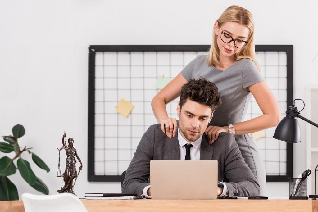 бізнес-леді робить масаж колезі на робочому місці в офісі, концепція офісної романтики
 - Фото, зображення