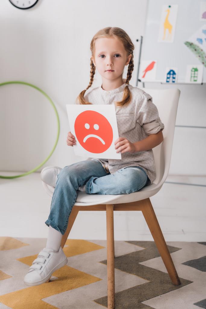 osamělé dítě sedí na židli drží smutný obličej symbol - Fotografie, Obrázek