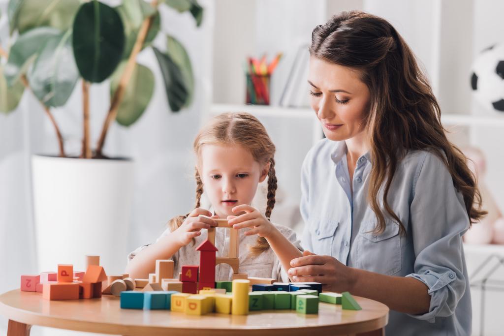 psychologist playing blocks with little child with autism syndrome - Photo, Image