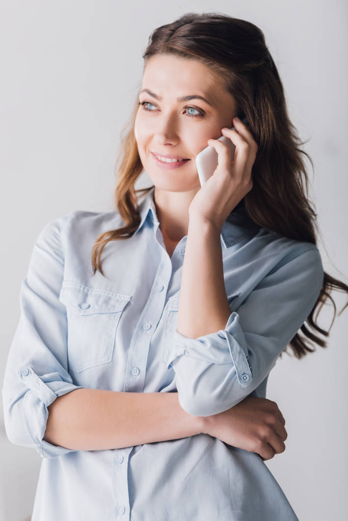 close-up portrait of smiling adult woman talking by phone and looking away - Photo, Image