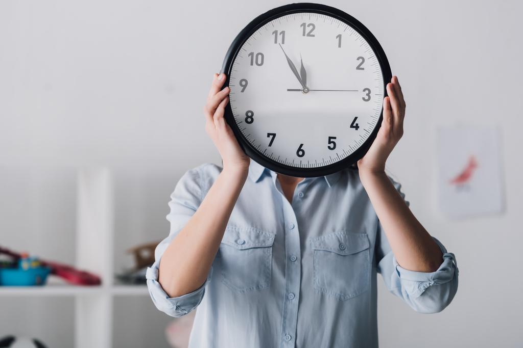 close-up portrait of woman covering face with clock - Photo, Image