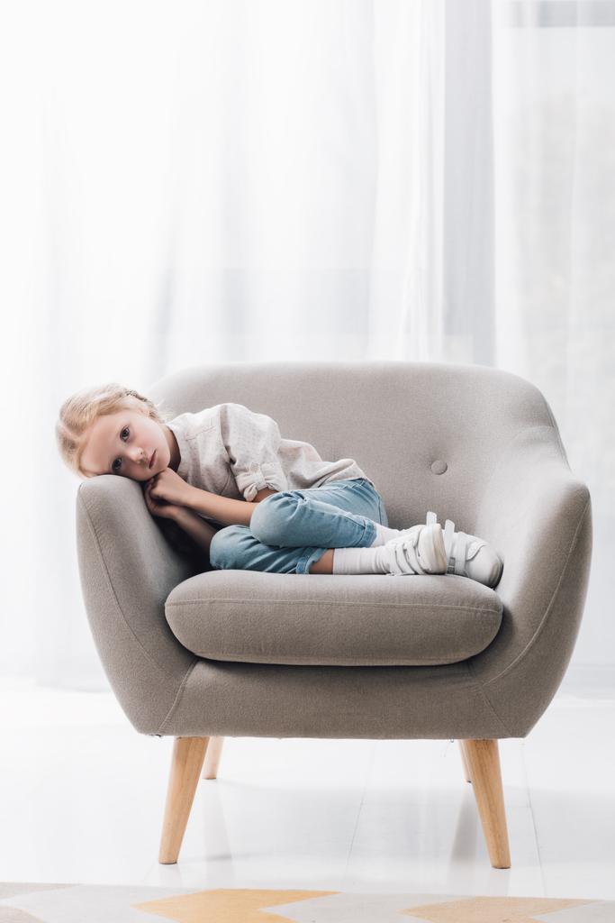 petit enfant déprimé couché seul dans un fauteuil
 - Photo, image