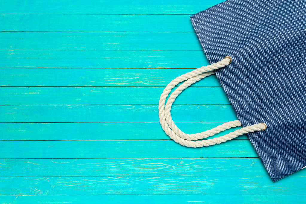 Tecido colorido saco de praia no fundo de madeira azul brilhante
 - Foto, Imagem