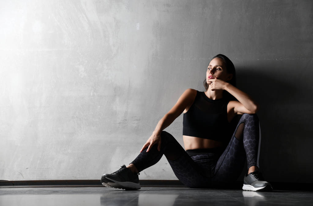Młoda kobieta sportowy po gimnastyka rozciąganie fitness ćwiczenia treningu, siedząc na podłodze  - Zdjęcie, obraz