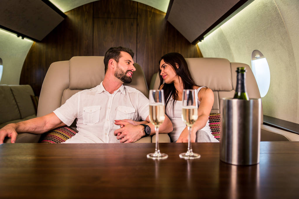 Šťastný pár cestuje na luxusní soukromé jet - mladí dospělí cestování na první třídy letu, pojmy o cestování a životní styl - Fotografie, Obrázek