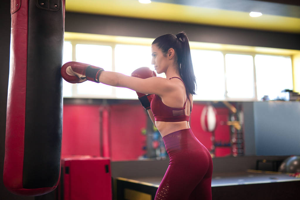Adult sportswoman boxing in gym - Photo, Image