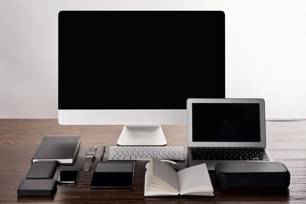 Monoblock-Computer mit verschiedenen Gadgets auf Holztisch isoliert auf grau - Foto, Bild