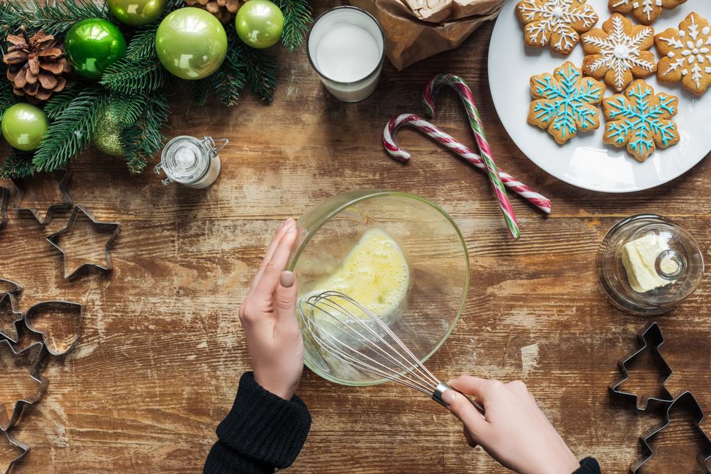 tiro recortado de la mujer haciendo masa para galletas de Navidad en la mesa de madera con corona decorativa
 - Foto, imagen