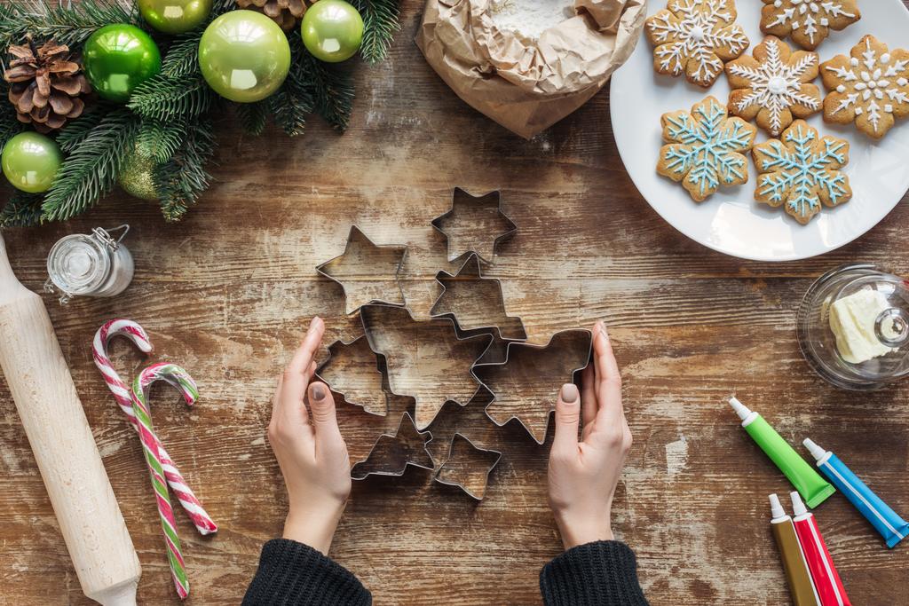fa asztali sült karácsonyi sütik cookie vágók gazdaság nő részleges megtekintése - Fotó, kép