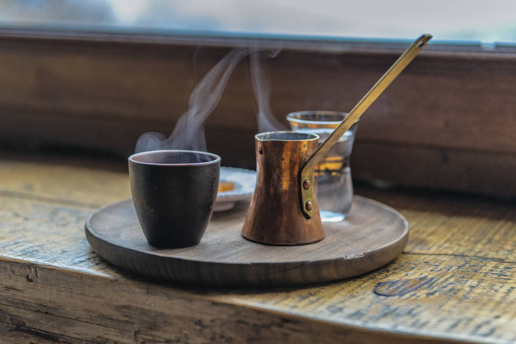 Чашка і горщик гарячої кави на старовинній дерев'яній тарілці. Перший ранковий напій
 - Фото, зображення