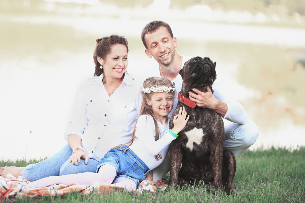 glückliche Familie mit Hund beim Picknick an einem sonnigen Sommertag. pregn - Foto, Bild