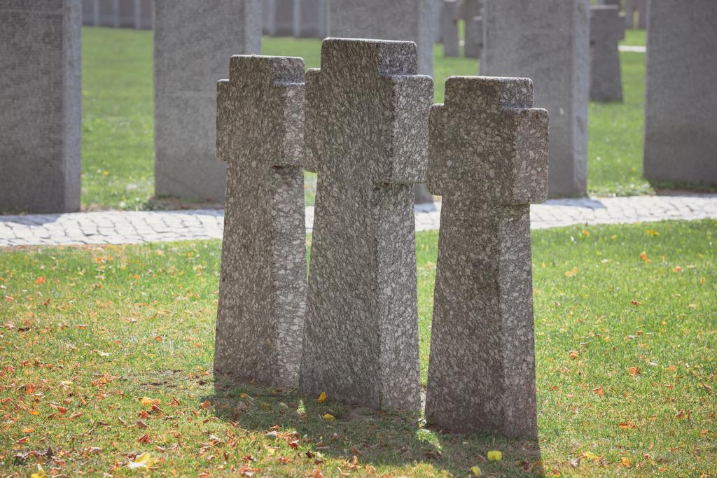 foco selectivo de lápidas conmemorativas antiguas idénticas colocadas en fila en el cementerio
 - Foto, Imagen