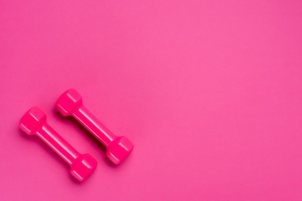 Premium Photo  Two pink female dumbbells isolated on pink background  close-up with copy space. fitness concept, weight loss and sport activity,  top view, flat lay