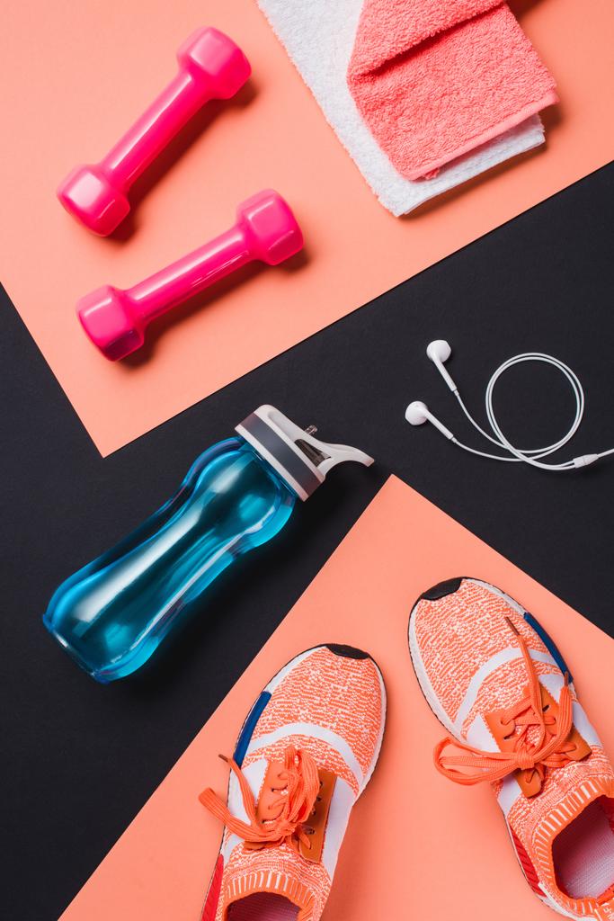 Flat lay with sneakers, dumbbells, sport bottle, towel and headphones on black background - Photo, Image