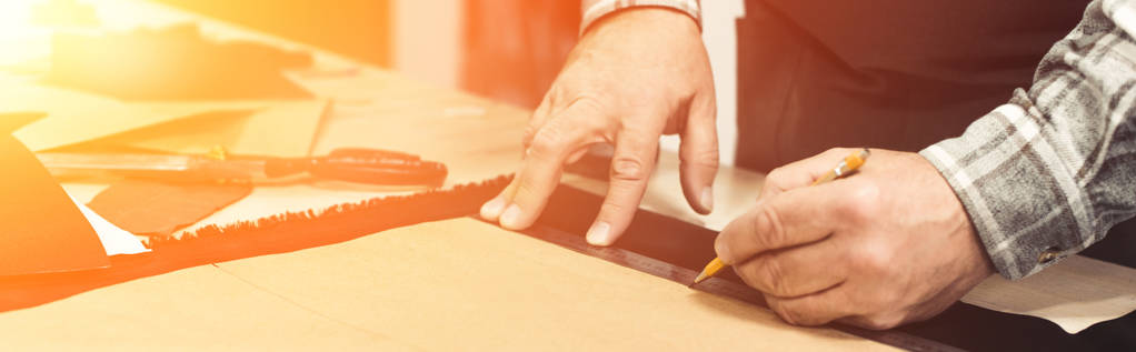 vue partielle de l'artisan sac à main faisant des mesures par crayon et règle en studio
 - Photo, image