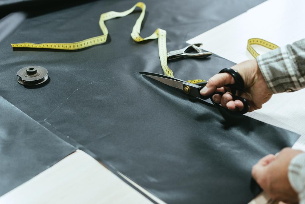 imagem cortada do artesão bolsa masculina cortando couro por tesoura na oficina
 - Foto, Imagem