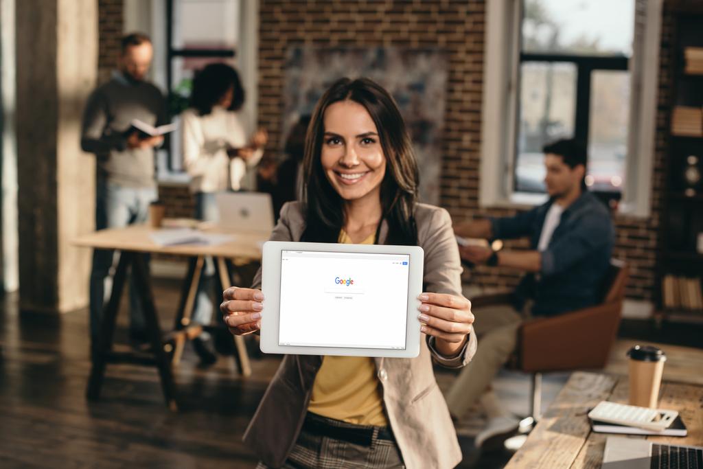 szczęśliwy dzień bizneswoman gospodarstwa tablet z witryny google na ekranie w biurze loft z kolegami z pracy za - Zdjęcie, obraz