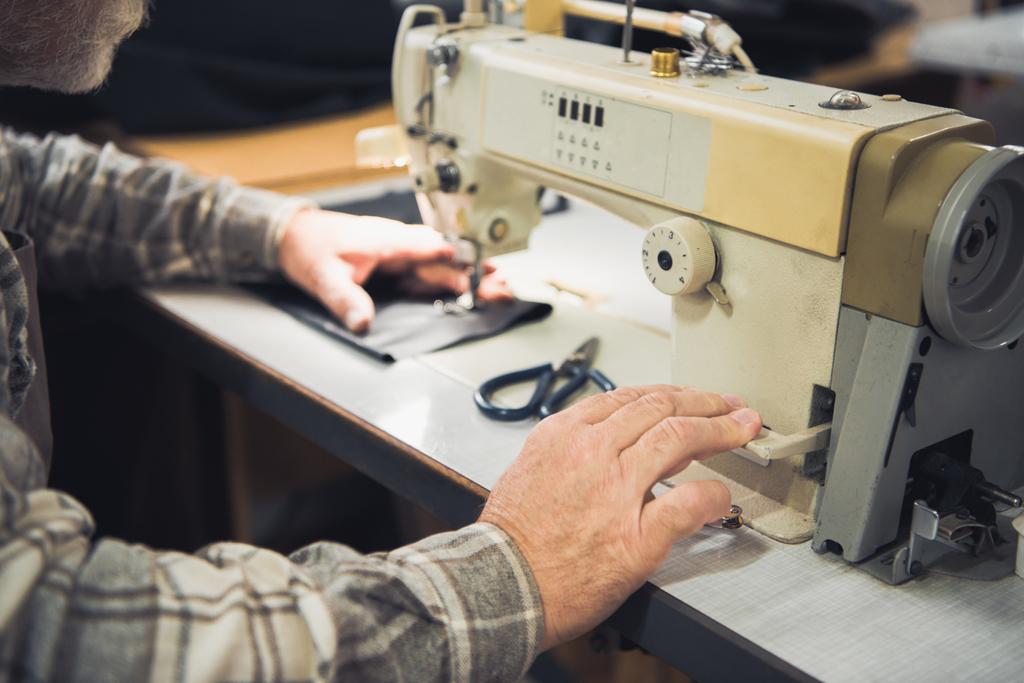 imagem cortada de alfaiate masculino trabalhando na máquina de costura no estúdio
 - Foto, Imagem