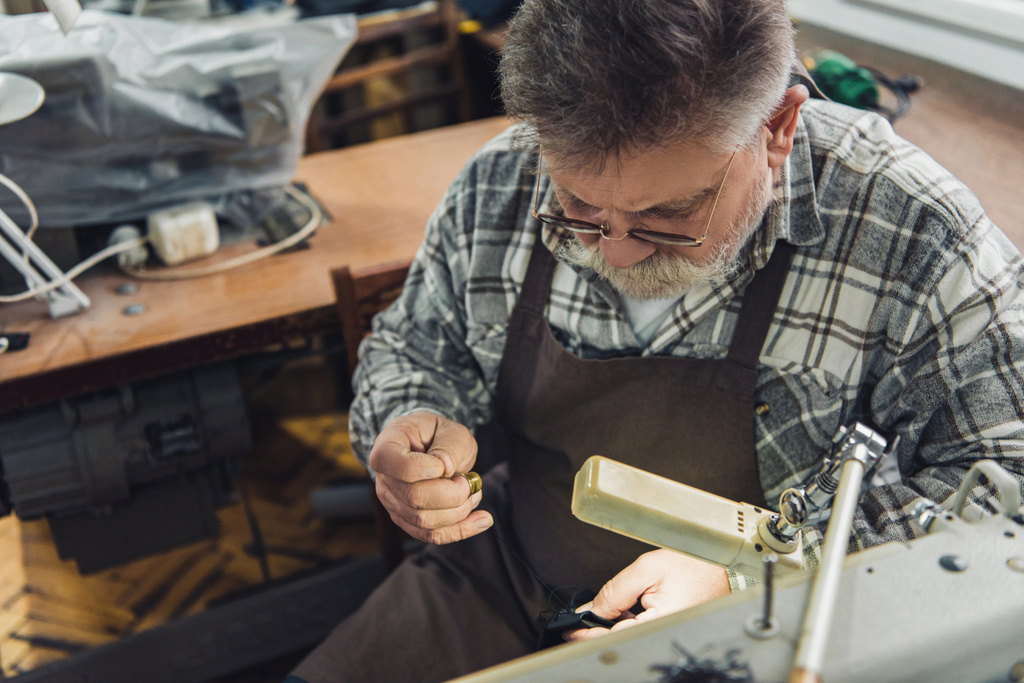 vista de ángulo alto del sastre masculino de mediana edad en gafas y delantal de costura en el taller
 - Foto, Imagen