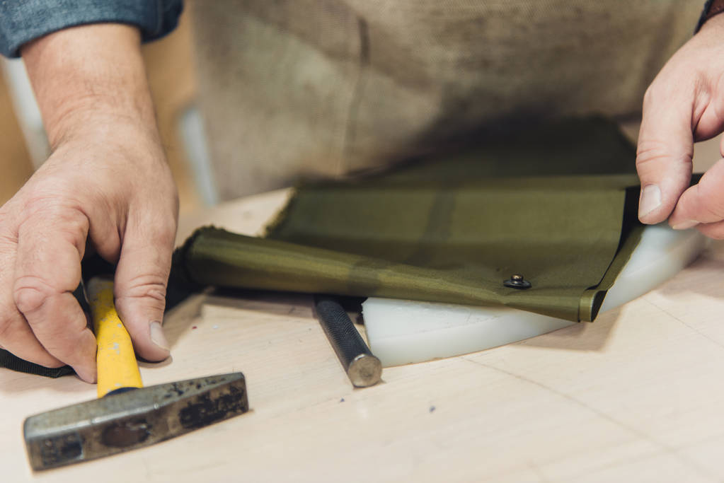 cropped image of male handbag craftsman working with hammer at studio - Photo, Image
